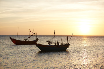 Naklejka na ściany i meble Fishing boats at sunset