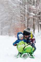 Fototapeta na wymiar mother and son on sledge