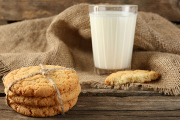 Tasty cookies and glass of milk on rustic wooden background