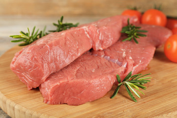 Raw beef steak with rosemary and cherry tomatoes