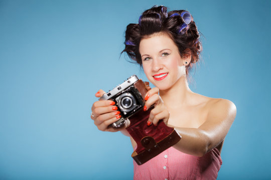 girl in hair curlers taking picture with old camera