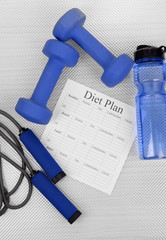 Diet plan and sports equipment top view close-up