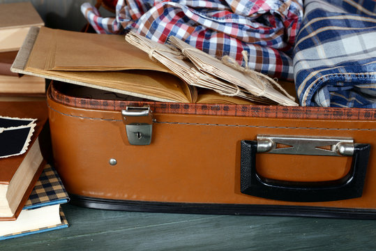 Vintage suitcase open with clothes and books