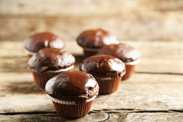 Tasty homemade chocolate muffins on wooden table