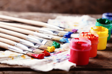 Brushes with colorful paints on dirty cloth