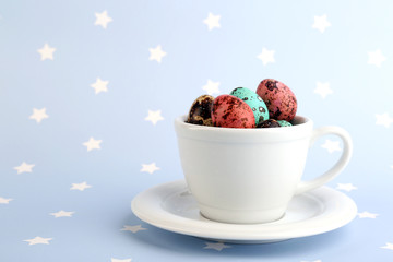 Bird colorful eggs in mug on bright background