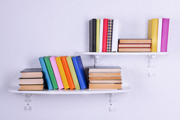 Books on shelves on white wall background