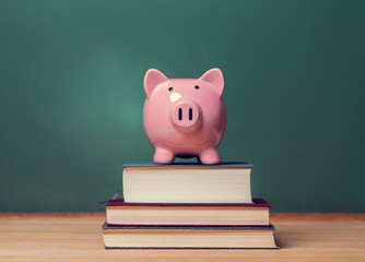 Piggy bank on top of books with chalkboard