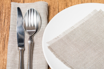 Empty white plate spoon, fork, knife