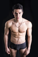 Fototapeta na wymiar Handsome, fit young man in underwear isolated on black