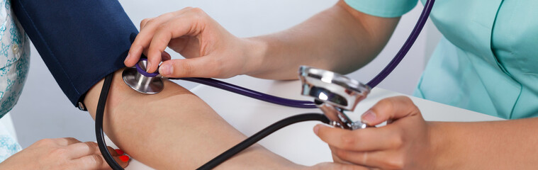 Doctor's hands measuring blood pressure - obrazy, fototapety, plakaty