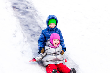 Fototapeta na wymiar Children riding the hills in winter