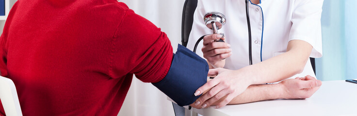 Female doctor measuring blood pressure