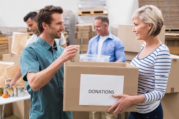Two volunteers holding a donations box
