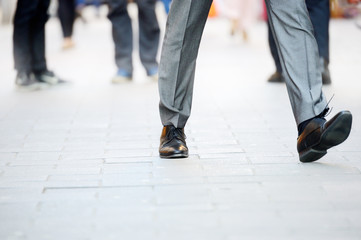 Business man in suit taking a big fast step forward