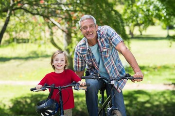 Fototapeta na wymiar Happy father on a bike with his son