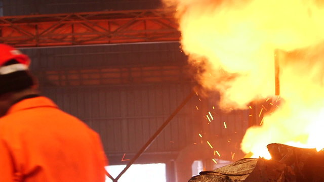 factory Hard work in the foundry, worker controlling of Putting and smelting iron in the furnace