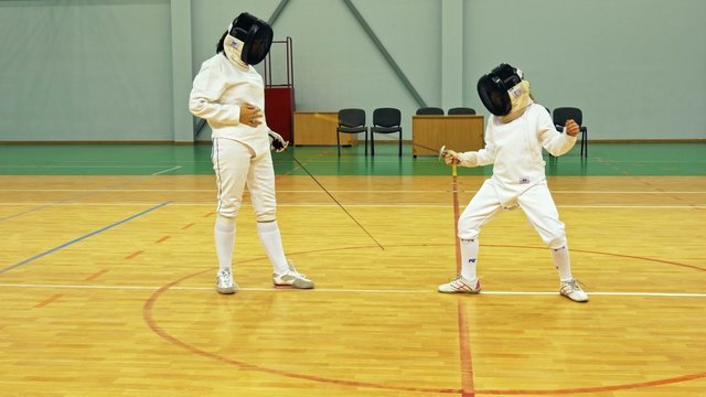 Little girl and trainer on a fencing training 