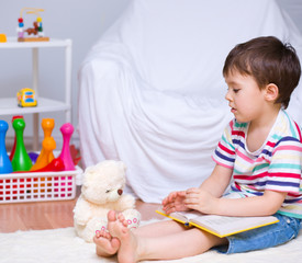 Little boy is reading a book