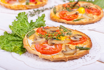 Mini tartlets with champignon, tomato, cheese, quail eggs and bl