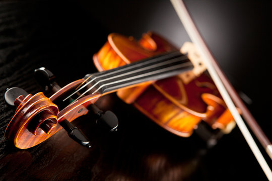 Violine mit Bogen vor dunklem Hintergrund