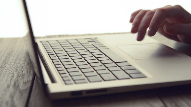 Woman Scrolls a Website Using Her Laptop