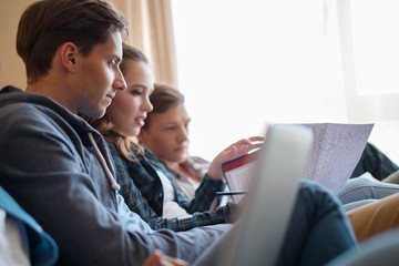 Three young students preparing for exams in apartment interior