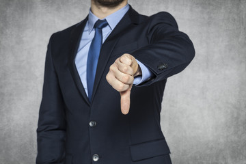 Businessman pointing thumbs down