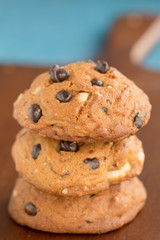 Stacked chocolate chip cookies on wooden board