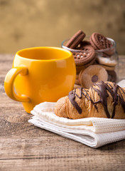 tea and croissant on wooden table