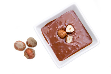 Chocolate with hazelnuts on a white background top view