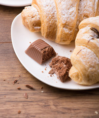Breakfast with coffee, milk and croissants on wooden table