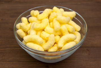 Corn snacks on bowl on wooden table