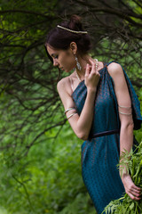 girl in dress with flowers in the forest