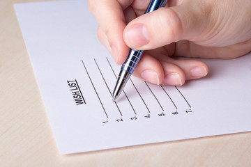 female hand writing her wish list