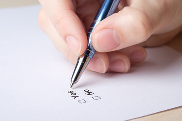 female hand filling survey with yes and no answers