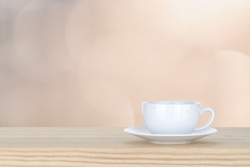 white cup of coffee on pine Wooden Table and bokeh,defocused lig