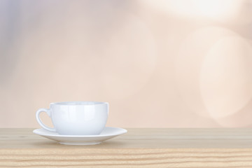 white cup of coffee on pine Wooden Table and bokeh,defocused lig