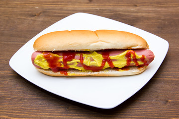 Hot dog on plate on wooden table
