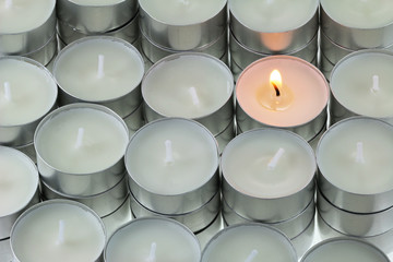 Closeup of Tea lights candle with one being lit