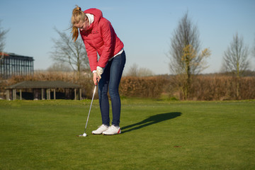 Junge Frau beim Putten auf Golf Grün