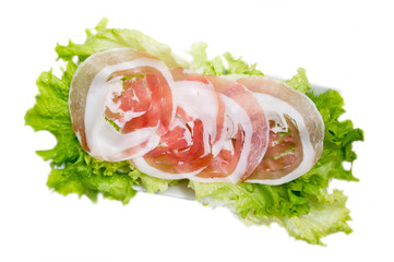 Rolled bacon on salad on white background top view
