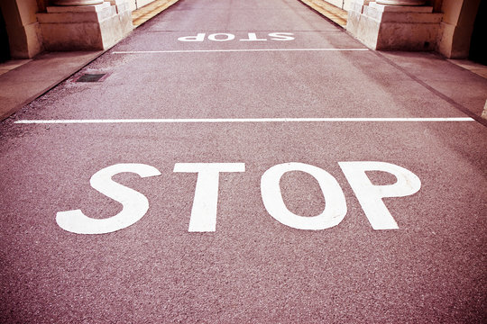 Stop written on red asphalt - concept image