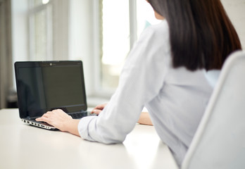 close up of woman typing on laptop at office