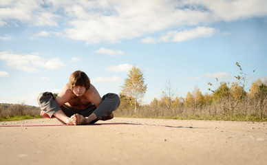 Fototapeta na wymiar man practices asanas on yoga in harmony with nature