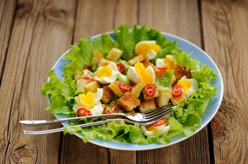 Salad Caesar with eggs, chili pepper and two forks selective foc