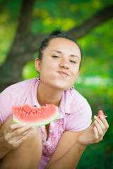 Cheerful woman eating watermelon