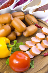 sausages on a wooden plate with vegetables in a restaurant