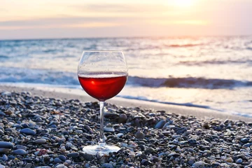 Cercles muraux Vin glass of wine on the beach at colorful sunset
