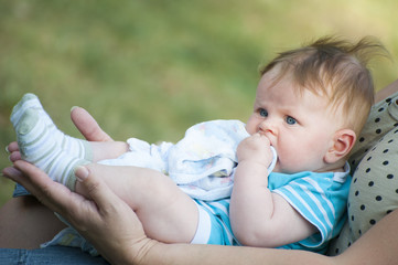 Newborn baby lying on female hands..